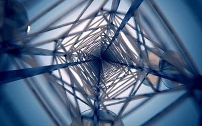 Aerial view looking up through a metal tower structure, symbolizing technological advancement and connectivity.