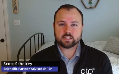 Scott Scheirey, Scientific Partner Advisor at PTP, discussing bioinformatics workflows and pipeline optimization, wearing a black PTP jacket and speaking from a home office setup with light blue walls and decorative wall art.